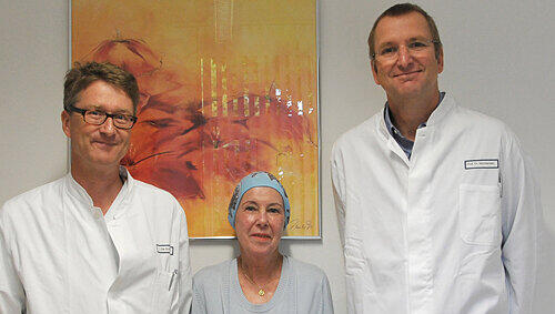 Renate M. ist gerettet. Mit der Patientin freuen sich Oberarzt Dr. Wolf Rösler (links) und Prof. Dr. Andreas Macksensen über den Therapieerfolg: „ein kleines Wunder. Renate M. ist gerettet. Mit der Patientin freuen sich Oberarzt Dr. Wolf Rösler (links) und Prof. Dr. Andreas Macksensen über den Therapieerfolg: „ein kleines Wunder.