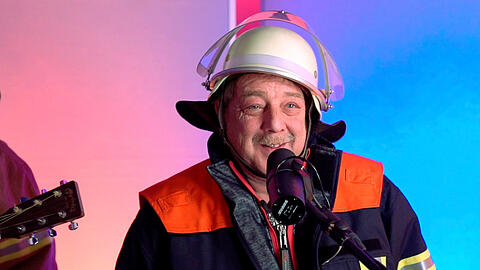 Feuerwehrmann Rudi Heimann singt sein Lied im Studio von Antenne Bayern.