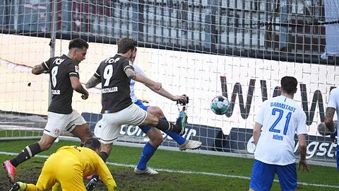 St. Paulis Guido Burgstaller (M) trifft gegen Darmstadts Torwart Marcel Schuhen zum 1:0.