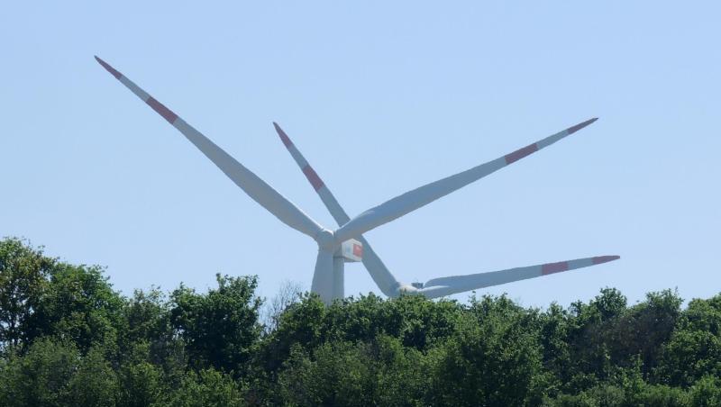 Windräder stehen hinter einem Wäldchen und einem blühenden Rapsfeld. Windräder stehen hinter einem Wäldchen und einem blühenden Rapsfeld.