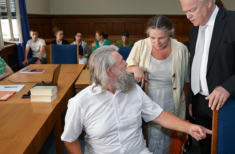 Der Angeklagte Gerhard Lebok (vorn), Guru der Sekte «Neue Gruppe der Weltdiener», seine Lebensgefährtin Susanne B. und sein Anwalt Axel Graemer warten am 15.07.2014 vor Prozessbeginn in einem Saal des Landgerichts Nürnberg-Fürth, links sitzt der Sohn Kilian B.