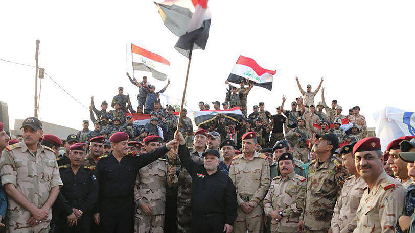 Iraks Regierungschef Haider Al-Abadi hält in Mossul die irakische Flagge in die Luft und erklärt offiziell den endgültigen Sieg über die IS-Miliz.
