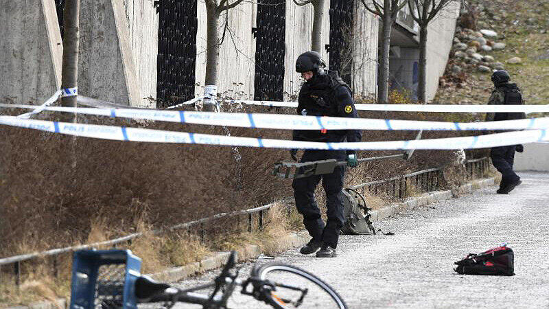 Polizisten untersuchen in Stockholm das Gebiet vor der U-Bahnstation Vaarby Gaard.
