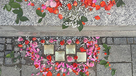 Zur Gedenkfeier mit Rosenbl&auml;ttern geschm&uuml;ckt: die vier neuen M&uuml;nchner Stolpersteine f&uuml;r die Familie Rosenfeld an der Buttermelcherstra&szlig;e 4.