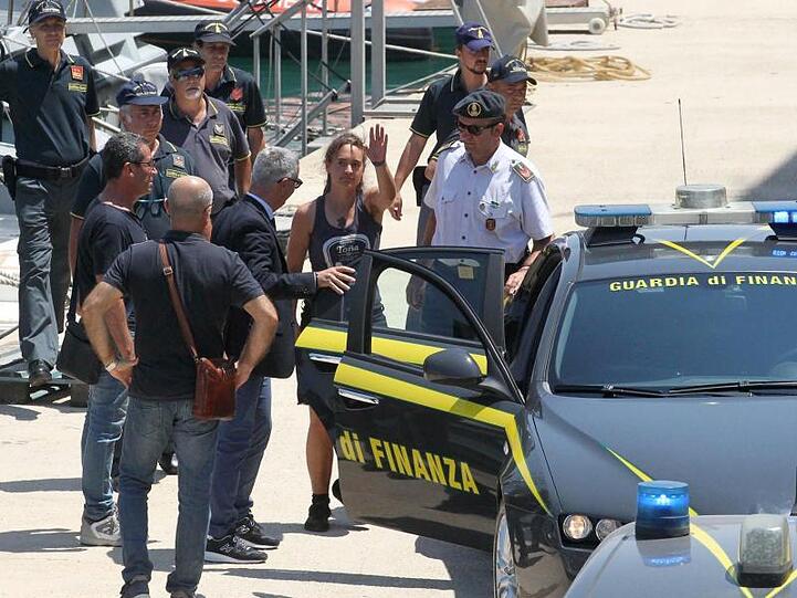 Carola Rackete steigt nach ihrer Ankunft in Porto Empedocle auf Sizilien in ein Polizeiauto.