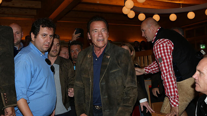 Erst eine kühle Maß, danach Dirigieren auf der Bühne: Die Bilder vom Schwarzenegger-Besuch im Schützen-Festzelt.