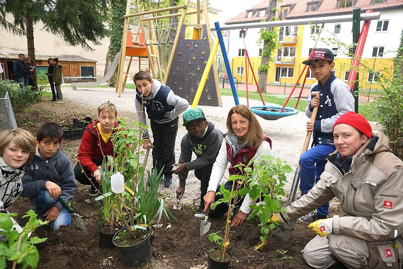 Maria Thon (geschäftsführerin BayWa Stiftung) und Manuela Dietmaier (Gärtnerei Brandl) mit Schulkindern beim Pflanzen vorm Kinder- und Jugendhaus in Kaulbachstraße.