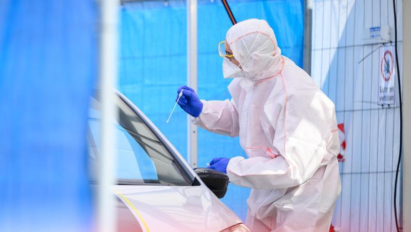 Ein Mitarbeiter führt in einem Corona-Abstrichzentrum einen Test durch. Ein Mitarbeiter führt in einem Corona-Abstrichzentrum einen Test durch.