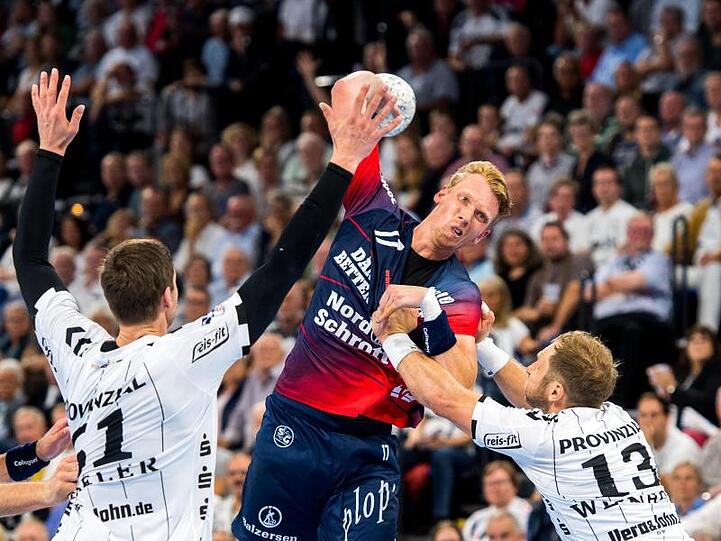 Die Kieler Hendrik Pekeler (l) und Steffen Weinhold (r) verteidigen am Wurfkreis gegen Simon Jeppsson von der SG Flensburg-Handewitt.