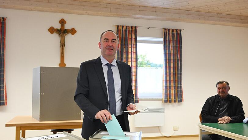 Hubert Aiwanger (l), Freie-Wähler-Spitzenkandidat und stellvertretender Ministerpräsident von Bayern, gibt in einem Wahllokal seine Stimme ab.