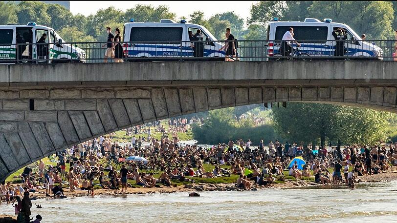 Dichtgedrängt sitzen die Menschen an der Reichenbachbrücke in der Sonne, während von oben die Polizei nur zuschauen kann.