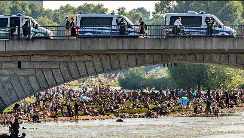Dichtgedrängt sitzen die Menschen an der Reichenbachbrücke in der Sonne, während von oben die Polizei nur zuschauen kann.