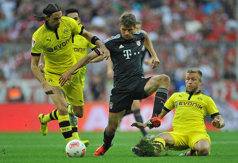 Thomas Müller (M) von und Neven Subotic (l) und Jakub Blaszczykowski von Dortmund kämpfen um den Ball.