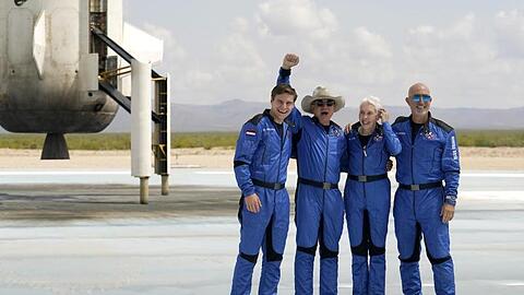 Oliver Daemen (l-r) aus den Niederlanden, Jeff Bezos, Gründer von Amazon und des Weltraumtourismus-Unternehmens Blue Origin, Wally Funk, ehemalige US-Pilotin, und Mark Bezos, Bruder von Jeff Bezos, stehen nach der Landung für ein Foto zusammen.