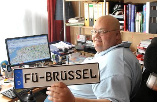 Vor dem Computer: Ralf Ochsler bei der Tour-Planung. Das Nummernschild hat er sich extra anfertigen lassen. Es wird an seinem Rollstuhl befestigt. In zwölf Tagen will er Brüssel erreicht haben.