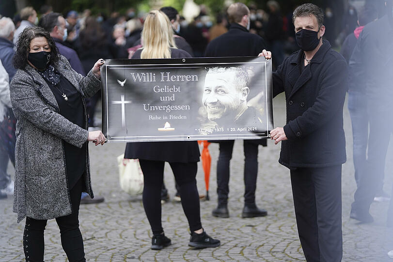 Fans halten am Friedhof ein Banner