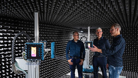 Apple-Chef Tim Cook (M.) zusammen mit zwei Mitarbeitern im Entwicklungszentrum des Konzerns in München.
