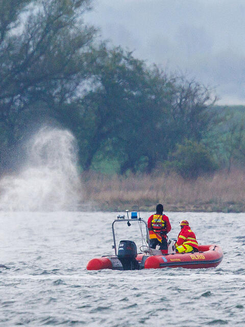 Der Buckelwal vor der Insel Poel bl&auml;st Luft ab und wird von Helfern auf Schlauchbooten beobachtet. Der bei Wismar gestrandete Wal hatte sich am Montagmorgen freigeschwommen und sich mehrere Kilometer fortbewegt.