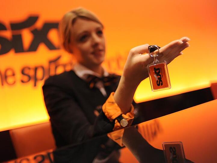 Eine Mitarbeiterin des Autovermieters Sixt übergibt einer Kundin den Schlüssel für einen Mietwagen. Foto: Andreas Gebert/Archiv