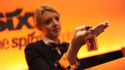 Eine Mitarbeiterin des Autovermieters Sixt übergibt einer Kundin den Schlüssel für einen Mietwagen. Foto: Andreas Gebert/Archiv