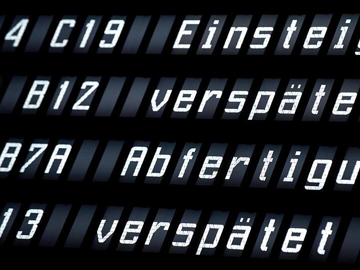 Eine Anzeigetafel zeigt in der Abflughalle des Flughafens Hannover die Verspätung mehrerer Flüge an.