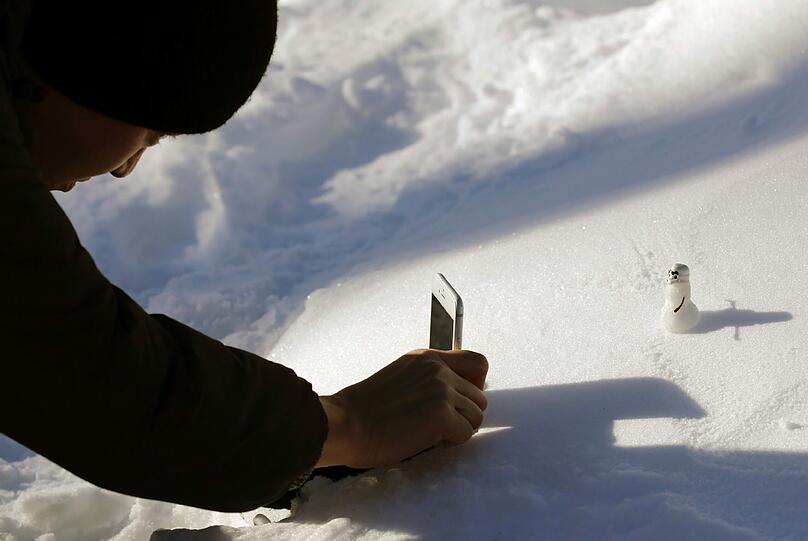 In New York fotografiert ein Spaziergänger im Central Park einen Mini-Schneemann. Am Wochenende hatte einen heftiger Wintereinbruch bis zu 69 Zentimeter Neuschnee an die Ostküste der USA getragen.