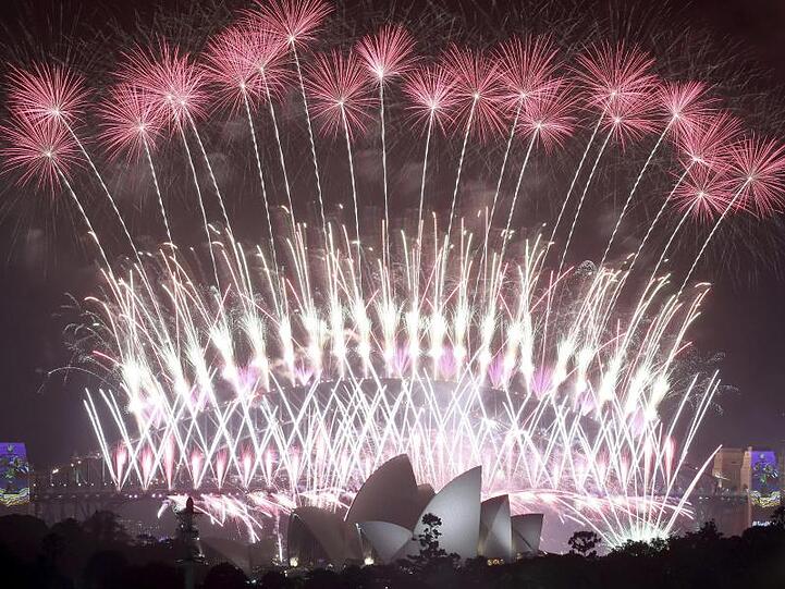 Ein Feuerwerk explodiert am Himmel über der Oper und der Harbour Bridge während der Neujahrsfeierlichkeiten in Sydney.
