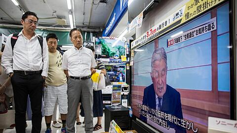 Passanten in Tokyo verfolgen die Ansprache des japanischen Kaisers Akihito. Foto: Christopher Jue
