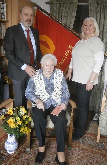 Zum 90. Geburtstag von Gerda Bürger besuchten Werner Brandl und Margit Meier als Vorstandsmitglieder die Jubilarin mit der Traditionsfahne des SPD-Ortsvereins Laim und gratulieren mit einem Blumenstrauß.