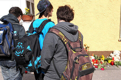 Jungendliche Dorfbewohner stehen fassungslos vor dem Haus, in dem die beiden Schwestern ermordet wurden.
