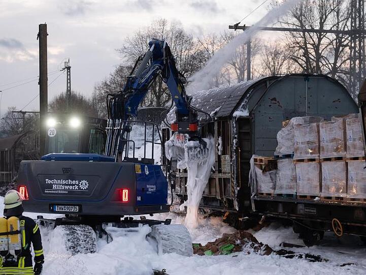Ein Bagger des Technischer Hilfswerkes beseitigt die Trümmer nach dem Brand.