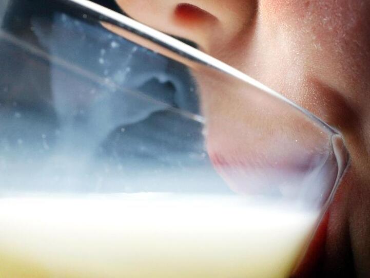 Ein Kind trinkt ein Glas Milch.