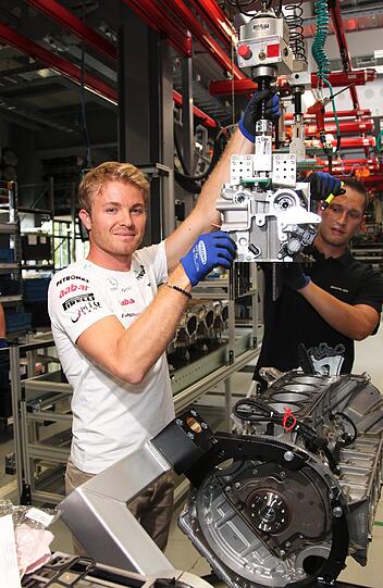 Die Formel 1-Stars auf neuen Wegen: Michael Schumacher und Nico Rosberg stellten ihre Fähigkeiten als Motoren-Monteure unter Beweis - im Mercedes AMG-Werk! Die Bilder.