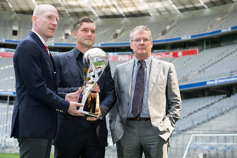 Bayerns Sportvorstand Matthias Sammer (v.l.), Dortmunds Sportdirektor Michael Zorc und DFL-Geschaeftsfuehrer Holger Hieronymus posieren mit dem Supercup in der Allianz Arena.