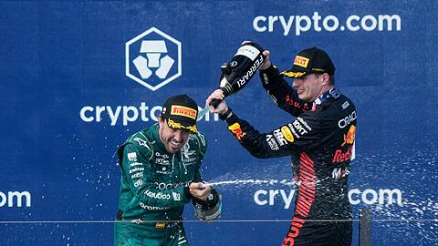 Red-Bull-Pilot Max Verstappen (r) feiert mit Fernando Alonso nach seinem Sieg. Alonso belegte den dritten Platz.