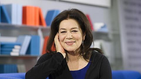 Hannelore Elsner sitzt auf der Buchmesse und lächelt. Foto: Arno Burgi/Archivbild