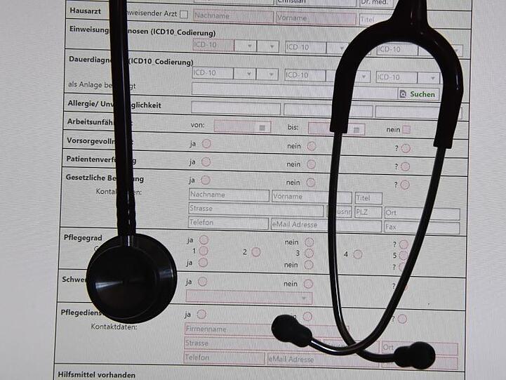 Ein Stethoskop vor einem Bildschirm mit einer digitalen Patientenakte.