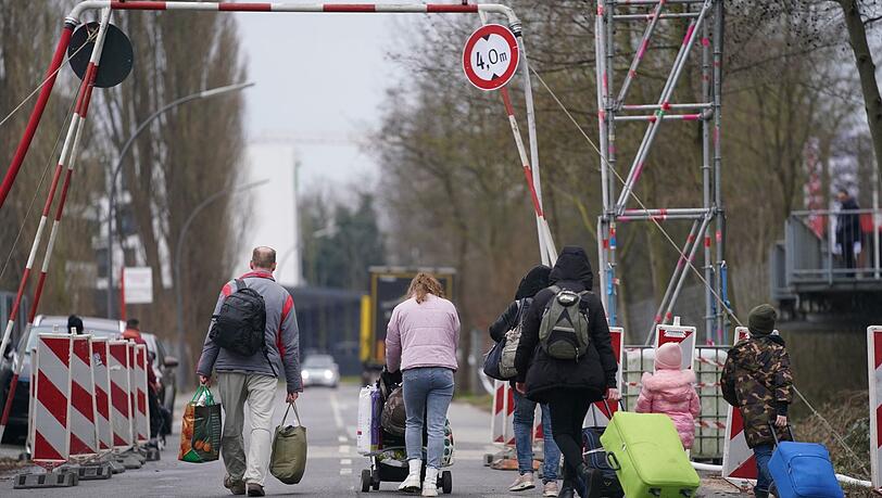 Aus der Ukraine geflüchtete Menschen verlassen mit ihrem Gepäck eine Unterkunft in Hamburg.