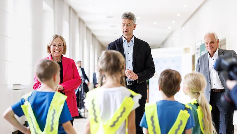 Irmgard Stippler, Vorstandsvorsitzende der AOK Bayern (v.l.), und Kultusminister Michael Piazolo (Freie Wähler) haben den Kindern in der St.-Anna-Grundschule Warnwesten mitgebracht. Irmgard Stippler, Vorstandsvorsitzende der AOK Bayern (v.l.), und Kultusminister Michael Piazolo (Freie Wähler) haben den Kindern in der St.-Anna-Grundschule Warnwesten mitgebracht.