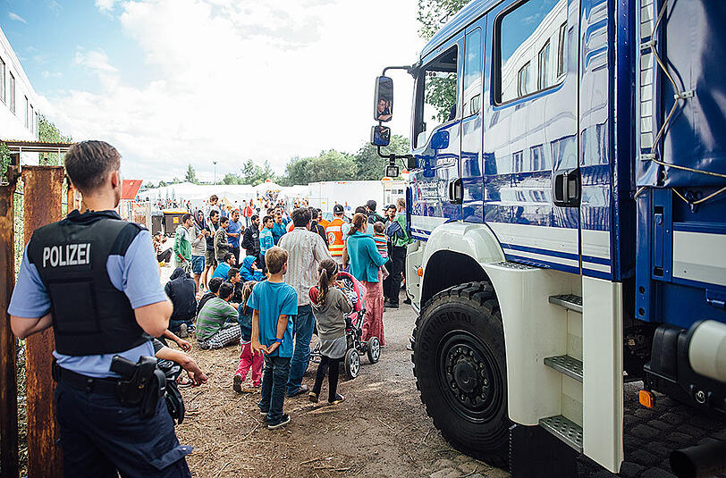 Flüchtlinge versammeln sich am Eingang des Aufnahmelagers an der Bremer Straße in Dresden.