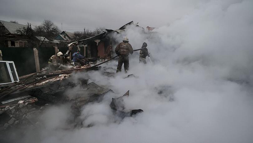 Feuerwehrleute löschen ein Feuer nach Beschuss im ukrainischen Charzysk.