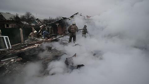 Feuerwehrleute löschen ein Feuer nach Beschuss im ukrainischen Charzysk.