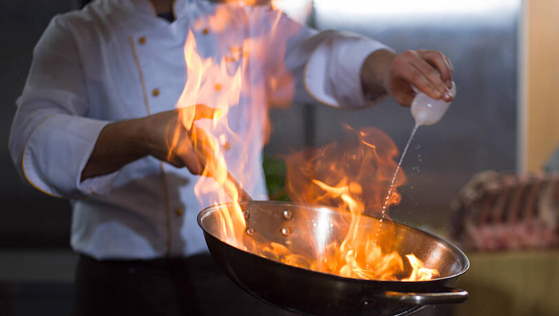 Koch flambiert mit Alkohol. Koch flambiert mit Alkohol.