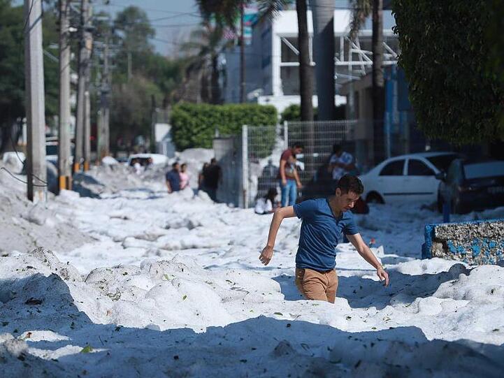 Ein Mann steht knietief im Hagel.