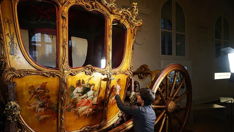 Die Restauratorinnen legen an der Kutsche Hand an. Die Restauratorinnen legen an der Kutsche Hand an.