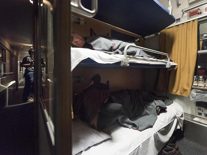 Reisende haben es sich in einem Nachtzug der Österreichischen Bundesbahnen (ÖBB) bequem gemacht.