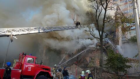 Feuerwehrleute arbeiten nach dem Beschuss von Geb&auml;uden durch eine Drohne.