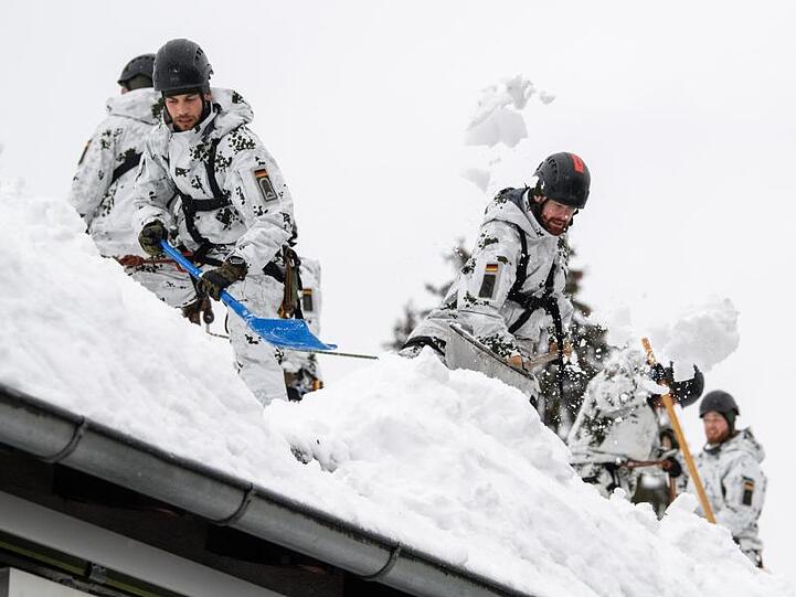 Einsatzkräfte der Bundeswehr befreien das Dach einer Straßenmeisterei von Schneemassen. Foto: Matthias Balk/Archiv