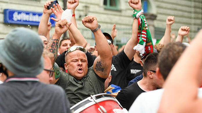Ungarische Fans machen unflätig auf sich aufmerksam, als sie am Wiener Platz auf die Busse zum Stadion warten.