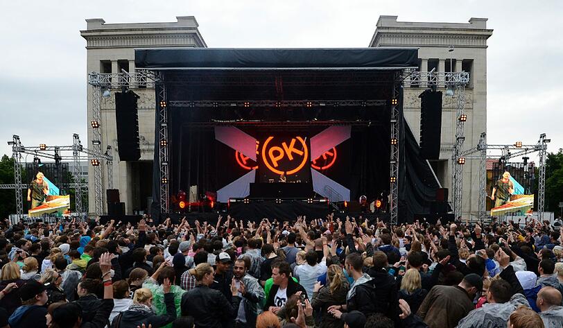 Wolkenbruch und Matsch statt "sky" und "sand" - trotzdem feiern am Sonntag 20.000 Fans den Berliner DJ Paul Kalkbrenner am Königsplatz.